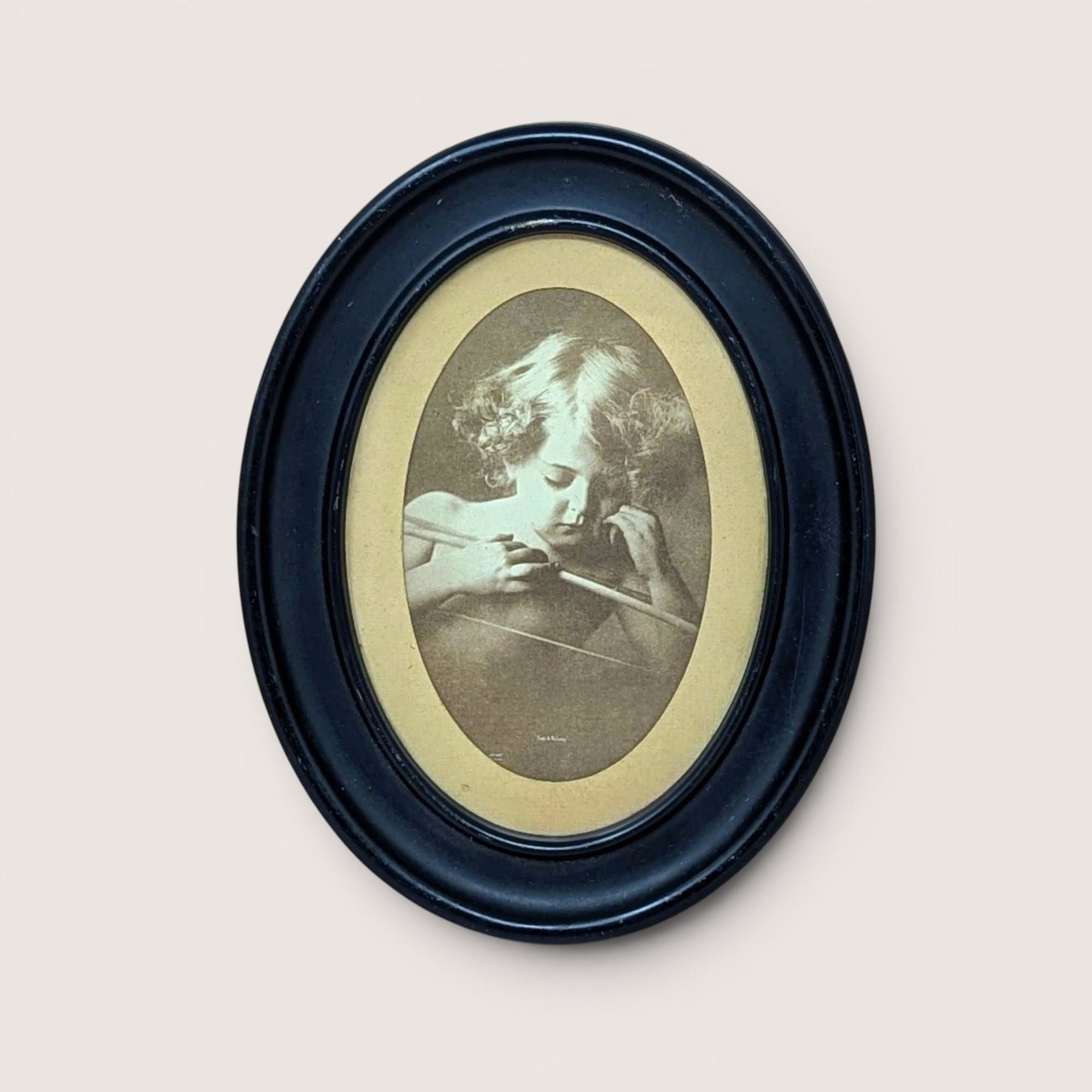 Vintage mid century sepia print of M.B. Parkinson Cupid Awake in a black oval wood frame.