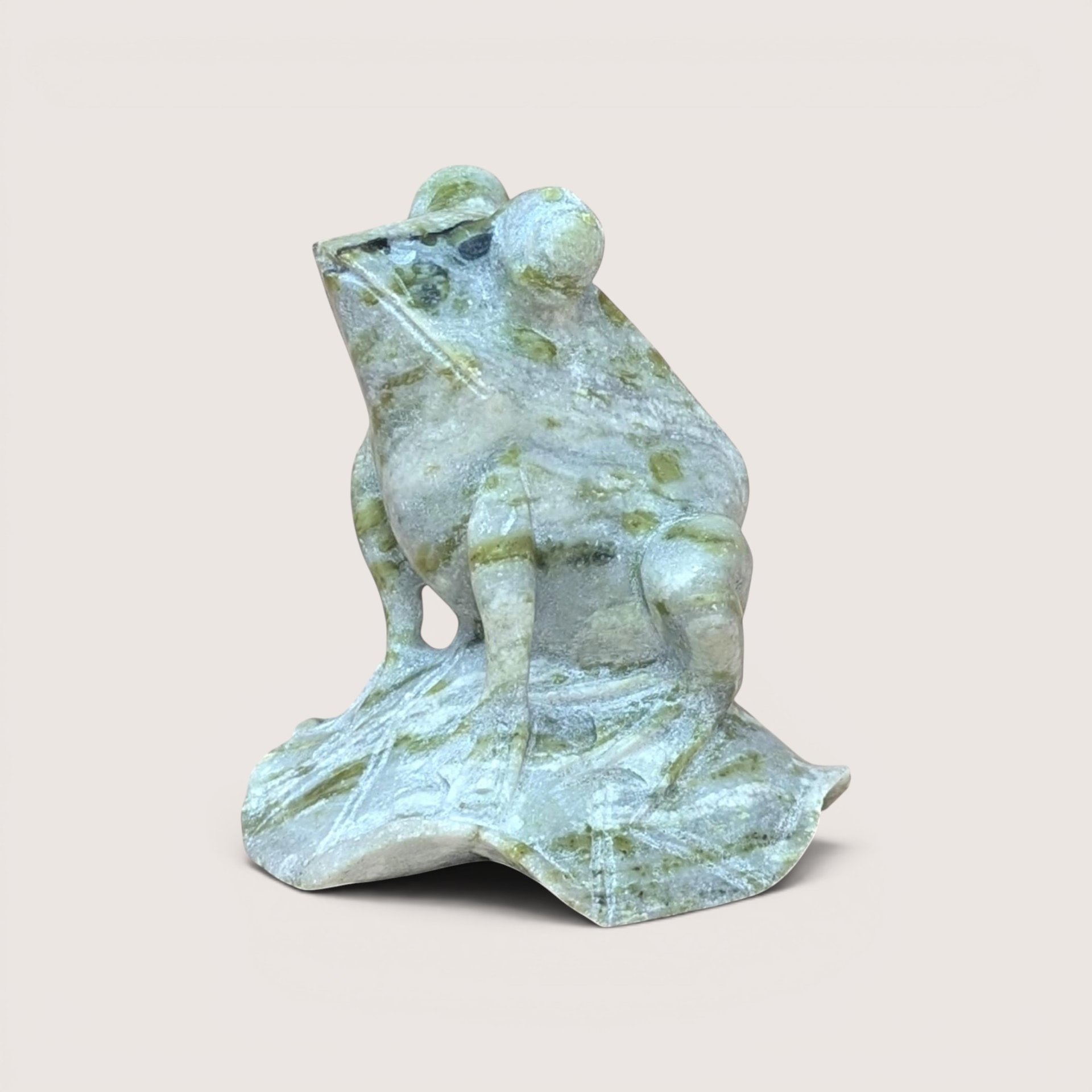 Hand-carved vintage green hardstone frog figurine perched on a carved stone leaf base.