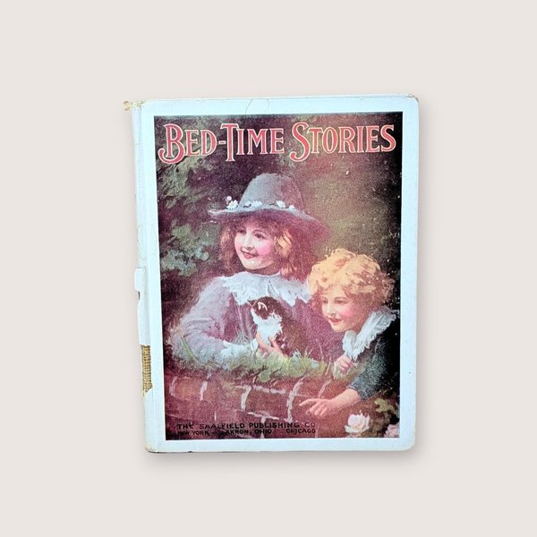 Antique 1914 copy of Bed-Time Stories by Saalfield with an illustration of children and a black and white kitten.