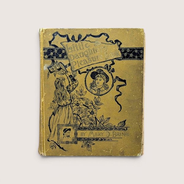 Antique gold book cover with black illustrations of a Victorian girl and floral designs by Mary D. Brine.