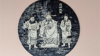 Round black and white veined marble plaque with a detailed white line engraving of three figures in traditional Chinese robes representing the City God (Cheng Huang). 8 inches in diameter.