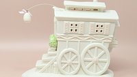 Dept. 56 Snowbunnies "My Woodland Wagon at Turtle Creek." A large, matte bisque porcelain wagon house with pink shutters, oversized wheels, and a hanging porcelain egg lantern. 6.5 inches tall.