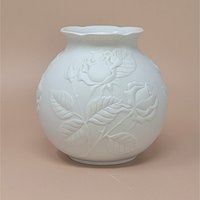 Kaiser West Germany white bisque porcelain vase with a globular body and flared rim. Features a high-relief embossed rose and leaf design with a soft matte finish. 5.5 inches tall.