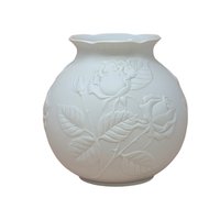 Kaiser West Germany white bisque porcelain vase with a globular body and flared rim. Features a high-relief embossed rose and leaf design with a soft matte finish. 5.5 inches tall.