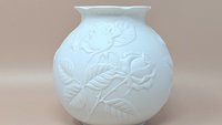 Kaiser West Germany white bisque porcelain vase with a globular body and flared rim. Features a high-relief embossed rose and leaf design with a soft matte finish. 5.5 inches tall.