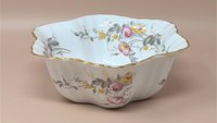 Scalloped white porcelain serving bowl with pink and yellow rose transfers. Features a hand-applied gold rim and a fluted, lobed body. Made in Germany, early 20th century.