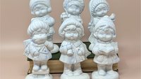 Set of six ceramic caroler figurines with a white pearlescent luster glaze and subtle blue accents. Includes children playing a drum, lute, and triangle, along with singers holding books. 5.5 inches tall.