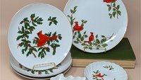 6-piece vintage Lefton Cardinal tableware set. Includes four white porcelain plates with hand-painted red cardinals and holly, one leaf-shaped candy dish, and one scalloped trinket bowl. Gold gilt rims throughout.
