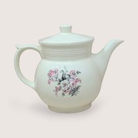 Vintage cream ceramic Drip-O-Lator coffee pot and lid. Features a central floral spray of pink tulips and white daisies. Sculptural scroll-top handle and tiered "stepping" on the neck. 7.25 inches tall.