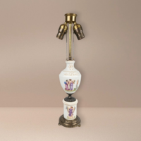 Tall antique Capodimonte-style porcelain lamp. Features high-relief classical figures of nymphs and cherubs. Cream body with gold gilt accents on an ornate brass base. Double pull-chain socket. 19 inches tall.