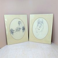 Pair of vintage 1975 Sharon Johnson prints. Fine charcoal-style drawings of a mother nursing a baby and a mother holding a child. Oval mattes on cream paper. 14x11 inches.