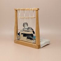 Vintage Navajo weaver doll sitting at a wooden loom. Features a miniature hand-woven textile in progress, a velvet-style bodice, and a turquoise-striped skirt on a faux-fur base. 8 inches tall.