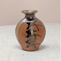 Vintage Brad Lee Henry studio pottery vase. Features a bulbous body in earthy red-brown with a metallic tenmoku drip glaze and black calligraphic slip-painted accents. 5 inches tall.
