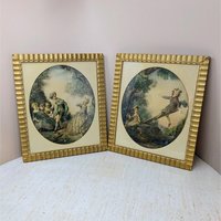 Set of two 1940s framed art prints by Nicolas Lancret titled "The Seesaw" and "Dropping the Handkerchief." Features pastoral Rococo scenes in ornate scalloped gold frames. 14.25 x 12.25 inches.