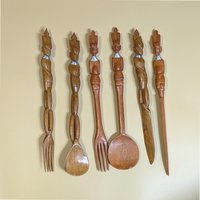 Set of 6 vintage hand-carved African tribal wooden utensils. Features elongated handles carved into various stylized human figures with silver-tone neck rings. Dark-stained tropical hardwood. 15.5 inches long.