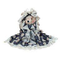 A vertical 12-inch handcrafted teddy bear with tan fur and movable limbs. Wearing an elaborate Victorian-style dark floral dress with voluminous cream lace trim and a matching oversized lace bonnet.