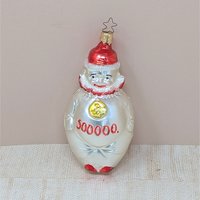 A vertical 5.5-inch blown glass clown ornament with a silvered body. The clown wears a red hat and ruff, with a gold medallion on its chest and "500,000" painted in red across the belly. Topped with a signature star-shaped metal cap.