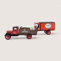 Two vintage red and brown die cast metal Anheuser Busch delivery truck banks. One is a flatbed carrying white yeast sacks, the other is an A and B Ice Cream panel truck.