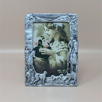 A vertical cast-metal picture frame with a weathered silver finish. Embossed hunters on horses and a pack of running hounds frame a portrait of a young girl with flowers.