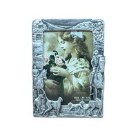 A vertical cast-metal picture frame with a weathered silver finish. Embossed hunters on horses and a pack of running hounds frame a portrait of a young girl with flowers.