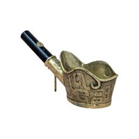 A traditional brass coal iron with a deep cup-shaped base and a black wooden handle. The exterior of the brass is decorated with raised scrollwork and ancient-style markings.