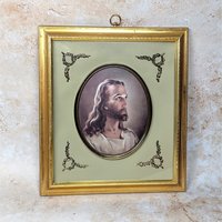 A vintage Turner Manufacturing framed picture of the Head of Christ on a tan textured background. The mid-century print is set within a sage green mat with brass corner filigree and a classic molded gold wood frame with a top hanging loop.