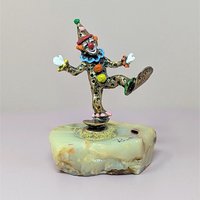 A hand-painted metal clown figurine by Ron Lee with 24k gold plating on a thick, natural onyx marble base against a neutral background.