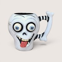 A whimsical white ceramic skull mug with large bulging eyes, a protruding red tongue, and a black-and-white striped bone handle against a neutral background.