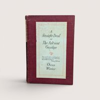 An antique book titled A Straight Deal or The Ancient Grudge by Owen Wister with a maroon cloth cover and cream paper label.