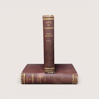 Two antique volumes of Life of Gladstone by John Morley with worn brown covers and gold lettering on the spines.