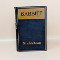 A 1922 hardcover copy of Babbitt by Sinclair Lewis, featuring a dark navy blue cloth cover with gold lettering and a simple rectangular border.