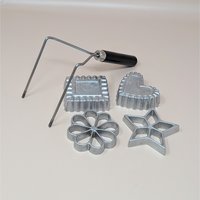 A vintage Nordic Ware kitchen tool set featuring a double metal handle and four cast aluminum molds in star, heart, flower, and square shapes.