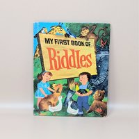 A vintage 1960 children's book titled My First Book of Riddles featuring a colorful cover with animals and two children holding a rooster and a duck