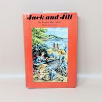 A vintage 1956 hardcover edition of Jack and Jill by Louisa May Alcott with a bright red dust jacket featuring children playing at the beach