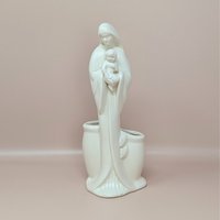 A vintage cream-colored Haeger Madonna and Child ceramic planter standing against a neutral background