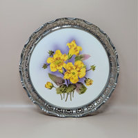 A vintage round porcelain tray featuring bright yellow flowers with a purple shadow background, enclosed in a decorative pierced silver metal rim