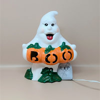 A hand painted vintage white ceramic ghost in file C2059 1.jpg holding three orange pumpkins that spell out BOO with a small grey RIP tombstone at the base
