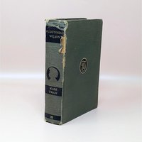 An anitque 1922 hardcover of Pudd'nhead Wilson by Mark Twain with a green cloth cover and a damaged spine showing the binding underneath