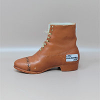 A vintage reddish-brown ceramic figurine shaped like a high-top men's dress boot with real string laces and delicate black wingtip patterns