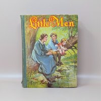 A vintage 1928 hardcover book titled Little Men by Louisa M. Alcott featuring a color illustration by Frances Brundage of children fishing by a stream