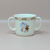 A vintage cream colored two handled mug featuring a group of rabbits on a sled with a border of running rabbits around the rim