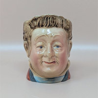 A vintage hand painted ceramic Toby jug depicting the character Mr. Pecksniff with a detailed smiling face and brown hair