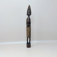 A vintage slender hand carved dark wood African figurine with a tall pointed headdress and a textured patterned skirt