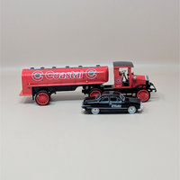 A red vintage-style 1920 Pierce Arrow tanker truck with Coastal Oil logos parked next to a smaller black 1949 Ford Coupe