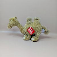 A tan shaggy plush camel toy with two humps and a red Gotta Getta Gund hang tag sitting on a neutral background