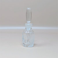 A vintage Lenox glass perfume bottle with the iconic Windswept frosted swirl pattern. The bottle features a tall, smooth clear stopper and is photographed against a neutral dune background.