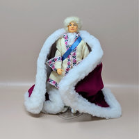 A vintage Peggy Nisbet doll representing King Louis XVI in elaborate royal attire. He wears a cream coat with floral trim, a blue sash, and a heavy burgundy velvet robe lined with thick white faux fur.