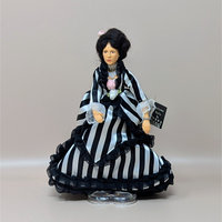 A vintage Peggy Nisbet portrait doll based on a Renoir painting. She wears a striking black and white striped gown with ruffled trim and lace cuffs. Her dark hair is styled up with a small pink rose.