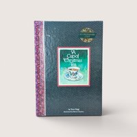 An autographed holiday book titled A Cup of Christmas Tea with a teacup illustration, centered on a beige background.