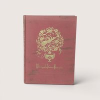 A vintage rose pink cloth hardcover book featuring a gold gilt peacock medallion on the front cover